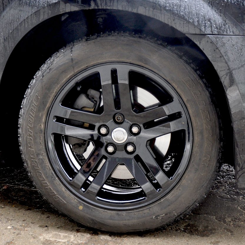 Покрашенный в черный и покрытый глянцевым порошковым лаком диск Chrysler с резиной.